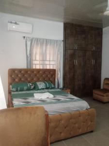 a bedroom with a large bed with a wooden headboard at Primenest Executive Suites in Gwagwalada