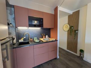 a kitchen with pink cabinets and a sink at La Casa Terracotta, ménage et linge inclus in Roses