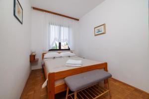 a small bedroom with a bed and a window at Apartment Renata in Njivice
