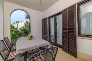 a balcony with a table and chairs and a window at Apartment Renata in Njivice
