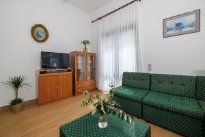 a living room with a couch and a tv at Apartment Renata in Njivice