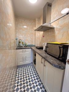 a kitchen with a sink and a microwave at Comfortable en-suite one bed room studio in Oxford +4 photos