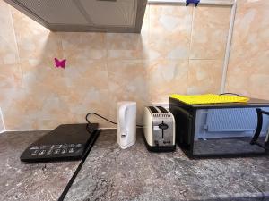 a counter top with a toaster and a toaster and a printer at Comfortable en-suite one bed room studio in Oxford