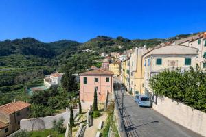 a city street with buildings and a blue car on a hill at Borgo & Terrazza - Le Case di Rio in Rio nellʼElba