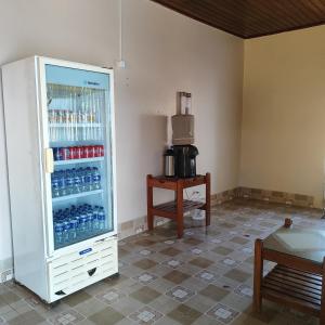 a refrigerator filled with bottles of water and a table at Hotel Bela Vista in Costa Marques