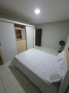 a white bedroom with a bed and a closet at Casa confortável a 3km do centro in Petrolina