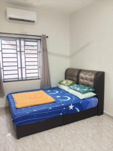 a bed in a room with a blue mattress and a window at Homestay Ayong in Parit Raja