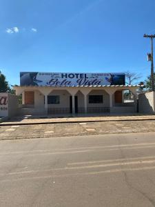 a hotel with a sign on the side of a street at Hotel Bela Vista in Costa Marques