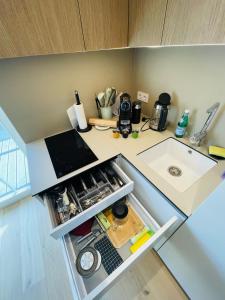 eine kleine Küche mit offenem Kühlschrank und Spüle in der Unterkunft Marè studio in Neringa