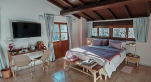 a bedroom with a bed and a desk and a tv at Cascina Silene in Castelmarte
