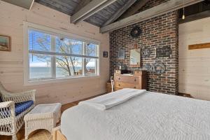 a bedroom with a bed and a brick wall at Gasthaus Fox by Juniper Holiday + Home in Bridgman