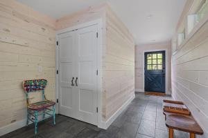 a hallway with a door and a chair and a table at Gasthaus Fox by Juniper Holiday + Home in Bridgman
