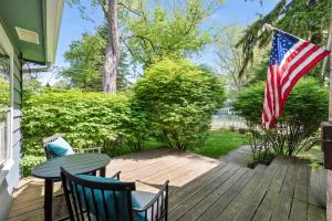 a patio with a table and chairs and an american flag at Nan's Escape by Juniper Holiday + Home in Union Pier