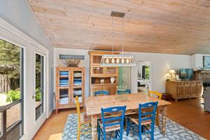 a dining room with a wooden table and chairs at Nan's Escape by Juniper Holiday + Home in Union Pier