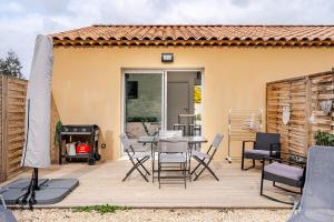 a patio with a table and chairs and a grill at Les deux pauses in Martigues