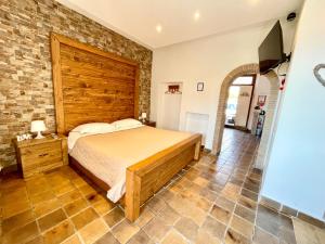 a bedroom with a bed and a brick wall at “La Casetta nel Borgo” in Cerveteri