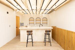 a kitchen with two bar stools and a sink at Lepetit in Oaxaca City