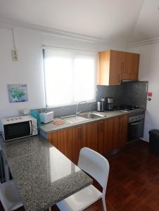 a kitchen with a counter and a sink and a microwave at Casa de Campo in Caniço +19 photos