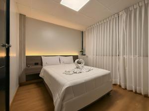 a bedroom with a white bed with a bow on it at Hotel Convencion in Trujillo