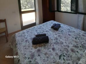 a bed with two bags sitting on top of it at Agriturismo La Tuva in Padru