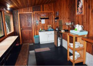 a kitchen with wood paneling and a counter and a sink at Refugio Ruka Cümelen in Panguipulli +39 photos