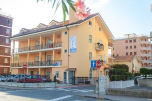 a yellow building on a street with a stop sign at Hotel Nello in Marina di Andora