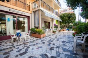 a patio with chairs and tables on a building at Hotel Nello in Marina di Andora