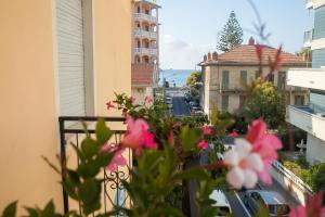 a view of a city street from a balcony with pink flowers at Hotel Nello in Marina di Andora