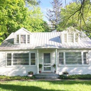 a white house with a white roof and grass at Hygge House in Harbert