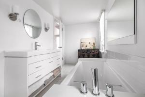 a white bathroom with a sink and a mirror at Hygge House in Harbert