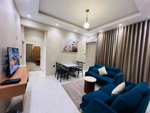 a living room with a blue couch and a table at شقق سكنية بابو ذر الغفاري in Medina