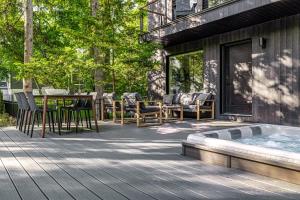 a deck with a hot tub and a table and chairs at Sunset on Pokagon in Michiana