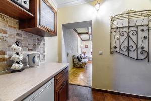 a kitchen with a counter and a living room at Zdesj Zhivet Schastje in Lviv