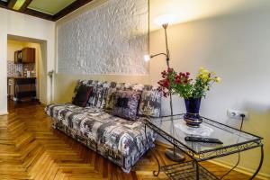 uma sala de estar com um sofá e uma mesa de vidro em Тут живе щастя Вул Вірменська Центр em Lviv