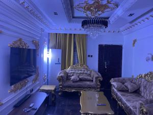 a living room with a couch and a chandelier at Family Holiday Inn, Fully Furnished 3 Bed Room Flat, With 24hour Solar Energy in Benin City