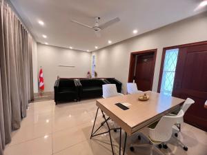 a dining room with a table and white chairs at Bridge Residency-1 F6 Islamabad in Islamabad