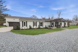 a house with a gravel driveway in front of it at Cozy Haven in Three Oaks
