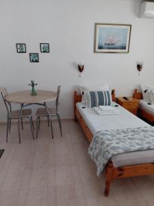 a room with two beds and a table and a table at Студиа Мансарда Ненови in Pomorie