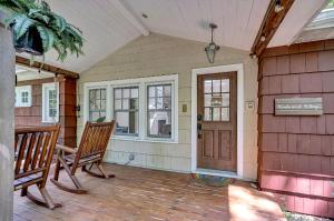 a porch with two wooden chairs and a door at Wonderwood Cottage in Sawyer