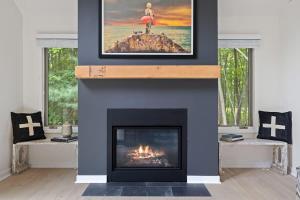 a living room with a fireplace with a fire place at The Coyote by Juniper Holiday + Home in Saugatuck