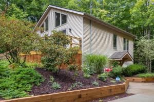 a home with a garden in front of it at The Coyote by Juniper Holiday + Home in Saugatuck