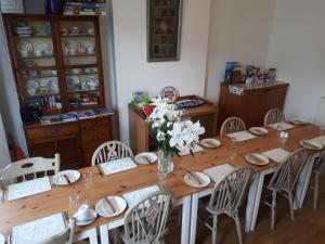 a long wooden table with chairs and a vase of flowers at The Westby in Bournemouth +11 photos