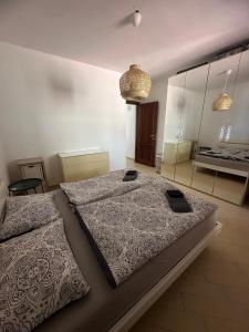 a large bedroom with two beds and a mirror at Hilltop Apartment in Castelsardo
