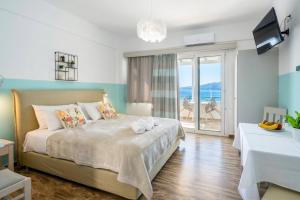 a bedroom with a bed with a view of the ocean at Theodora Rooms in Poros