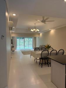 a dining room and living room with a table and chairs at Landed IOI City Mall Country Heights Putrajaya Homestay in Kajang