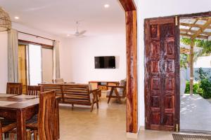 an open door into a living room with a table and chairs at Kikoi Boutique Hotel in Michamvi