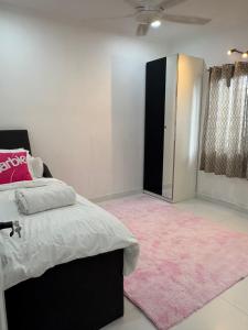 a bedroom with a bed and a pink rug at Landed IOI City Mall Country Heights Putrajaya Homestay in Kajang