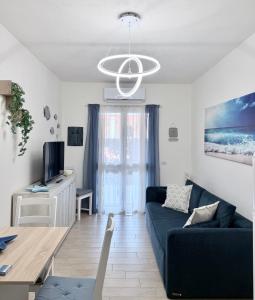 a living room with a blue couch and a table at Appartamento Sardinia Escape in residence - Palau in Palau