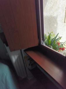 a window sill with a bench and plants in it at Ξενώνας Μυρτώ in Andritsaina