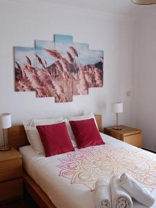 a bedroom with a bed with two red pillows at Casa de Campo in Caniço